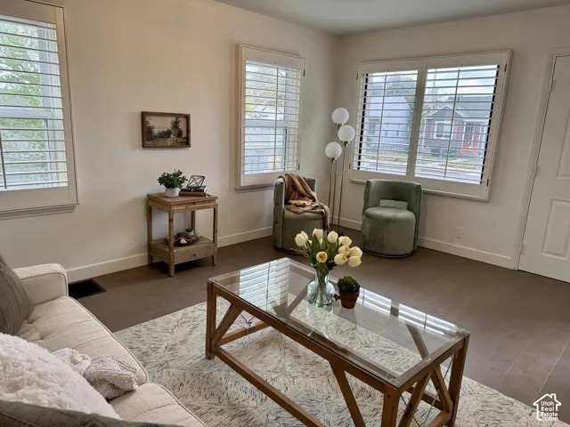 Large and light front living room with plantation shutters, real wood flooring and huge windows.