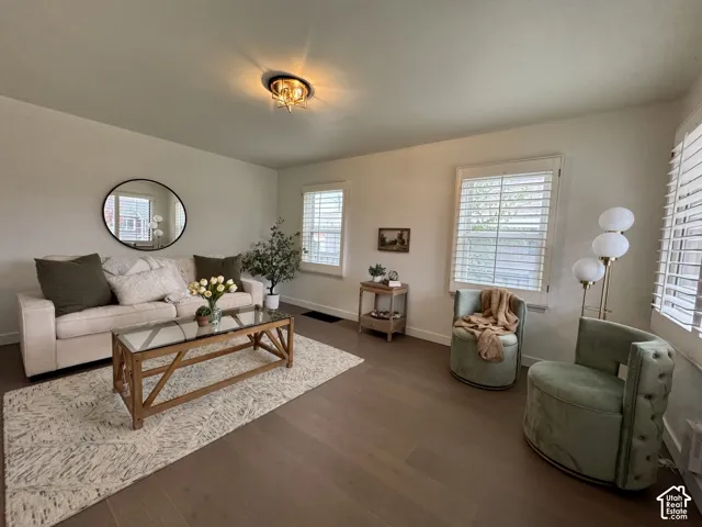 Large and light front living room with plantation shutters, real wood flooring and huge windows.