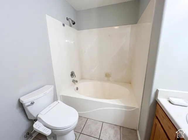 Deep soaking tub with integrated surround, chrome shower fixtures, and tile flooring