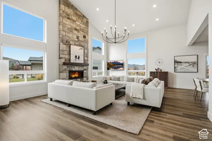 Vaulted ceiling living area with a stone-clad fireplace and wood-finish flooring