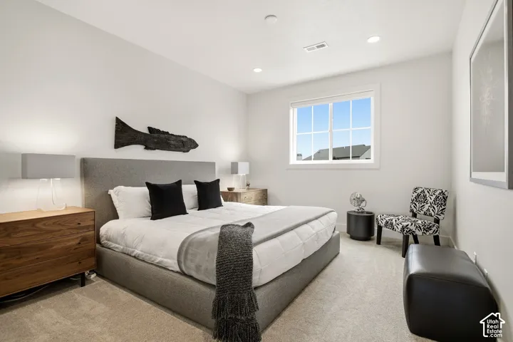 Spacious room with light-colored walls, recessed ceiling lighting, and a large window