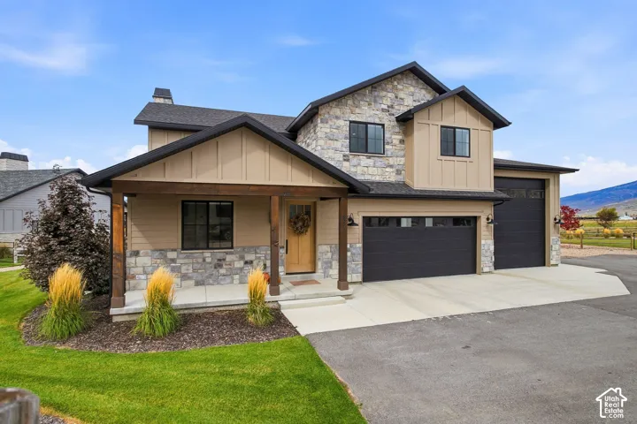 Modern-style exterior featuring stone accents, board and batten siding, and a covered entry