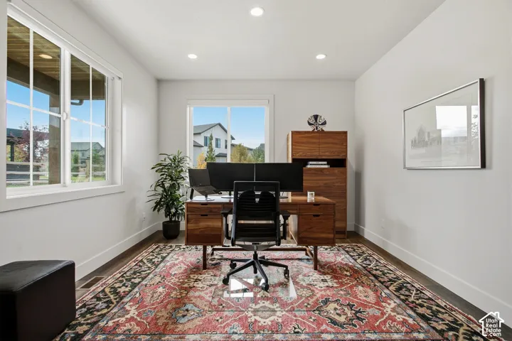 Recessed lighting, wood-finish flooring, and multiple windows with white trim