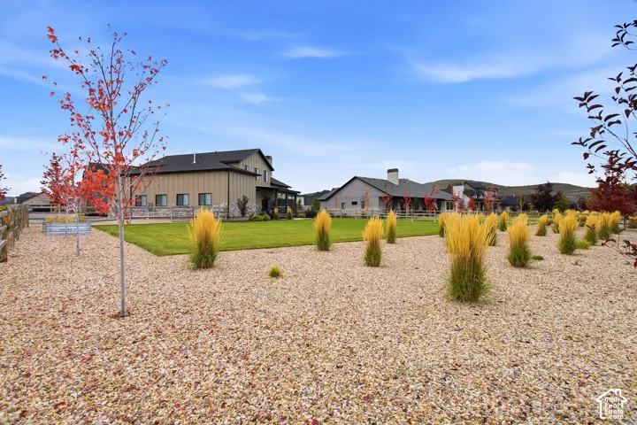 Expansive outdoor area featuring decorative gravel, ornamental grasses, and mature trees with autumn foliage