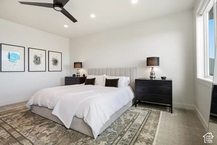 Recessed lighting, ceiling fan, large window, light-toned wall finishes, and carpeted flooring