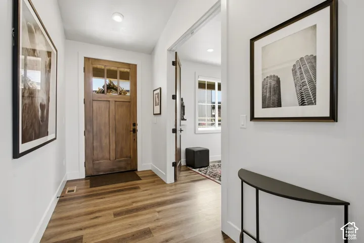 Entryway featuring wood-finish flooring, a solid wood front door with glass lites, recessed lighting, and white trim