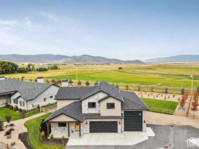 Contemporary home with stone and siding exterior, two-car garage, and concrete driveway