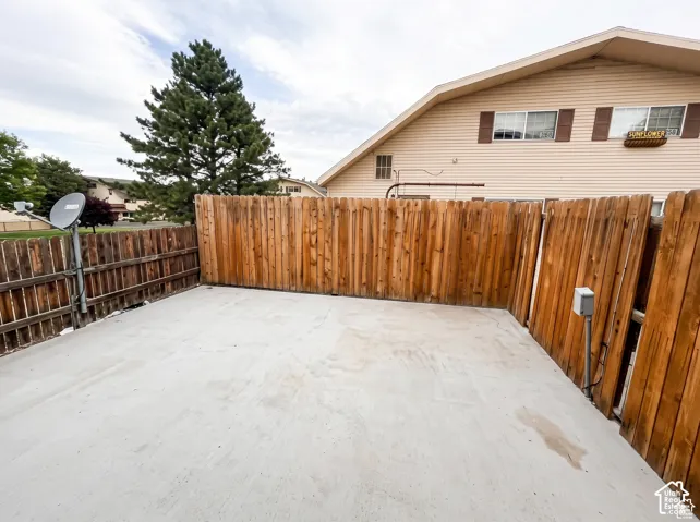 Concrete patio enclosed by vertical wood fencing