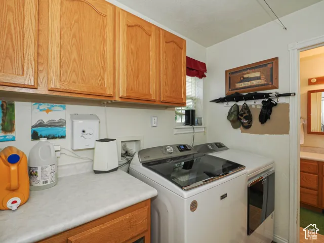 Laundry area featuring wood cabinetry, laminate countertops, and a window with blinds