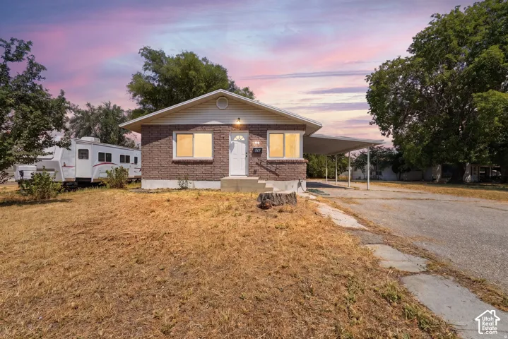 Single-story residence featuring a brick exterior, gabled roofline, and an attached carport