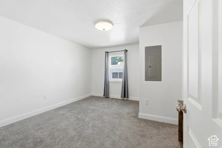 Neutral-toned carpeted flooring, white wall finish, recessed ceiling lighting, and a single-pane window