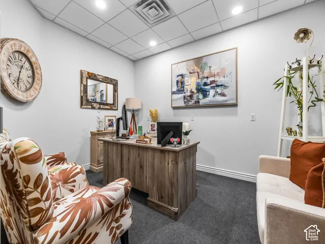 Enclosed interior room with a drop ceiling, recessed lighting, and wall-to-wall carpeting
