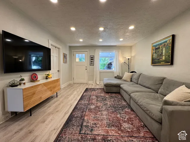 Living area featuring wood-finish flooring, recessed lighting, and a multi-lite exterior entry door