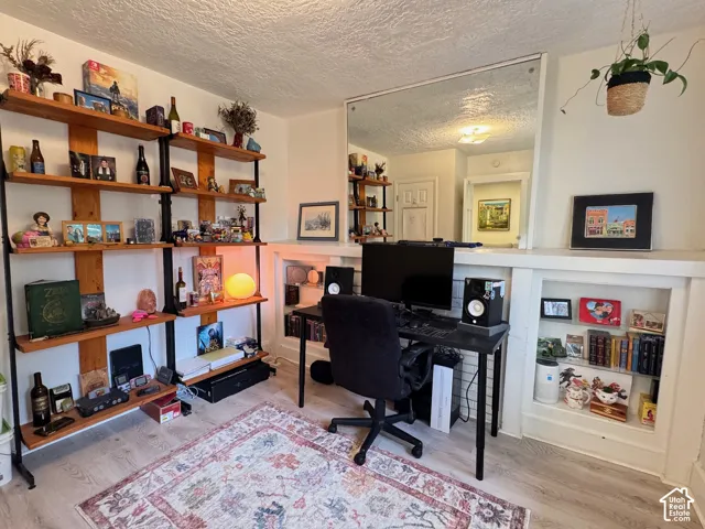 Wood-finish flooring, floor-to-ceiling metal and wood shelving unit, recessed wall shelving, and a large wall-mounted mirror