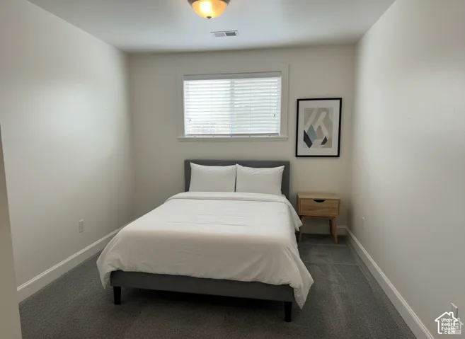Neutral interior room featuring wall-to-wall carpeting, window with blinds, and flush-mount ceiling lighting