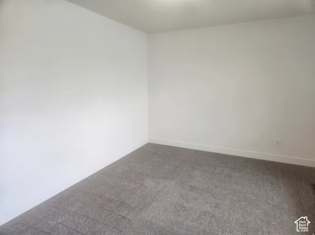 Neutral-toned interior space featuring light-colored wall paint and grey wall-to-wall carpeting