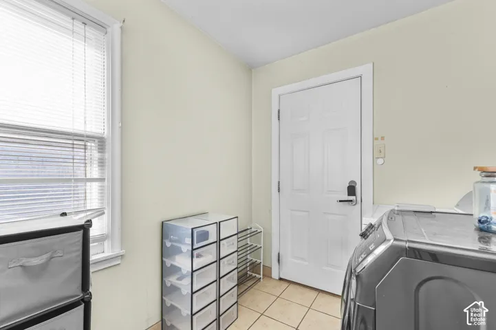 Neutral wall palette with tile flooring, featuring a window with horizontal blinds and a paneled exterior door