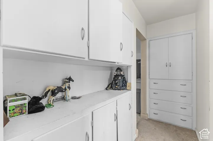 Built-in white cabinetry featuring upper storage cupboards, lower storage cabinets, and a integrated dresser with four drawers