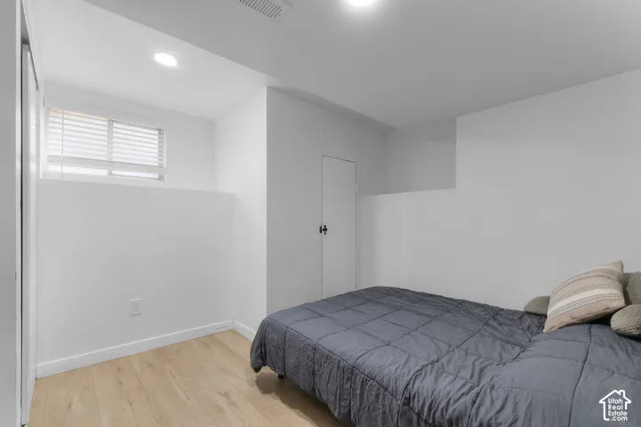 Wood-finish flooring, recessed lighting, and a window with horizontal blinds