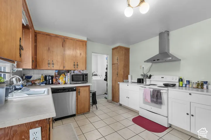 Kitchen featuring natural wood cabinetry, white laminate countertops, stainless steel dishwasher, white range with a stainless steel vent hood, and tile flooring