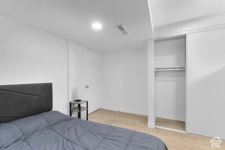Neutral interior featuring light-tone wood-finish flooring, recessed lighting, and a closet with sliding doors