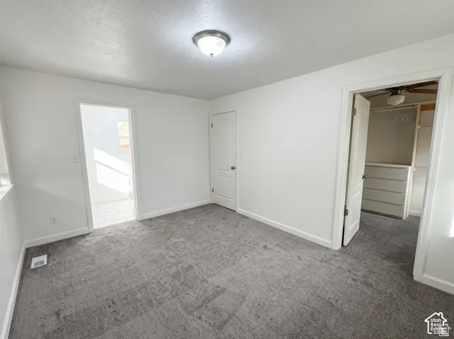 Neutral-toned carpeting, minimalist white wall finish, interior panel doors, and overhead flush-mount lighting