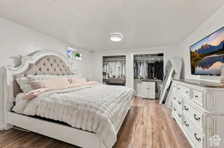 Wood-finish flooring, dual built-in closets with shelving, and recessed ceiling lighting