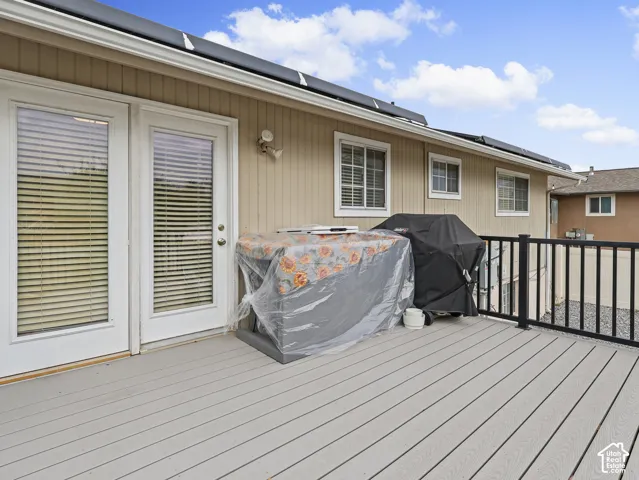 Exterior deck featuring composite decking, vertical vinyl siding, and black metal railings