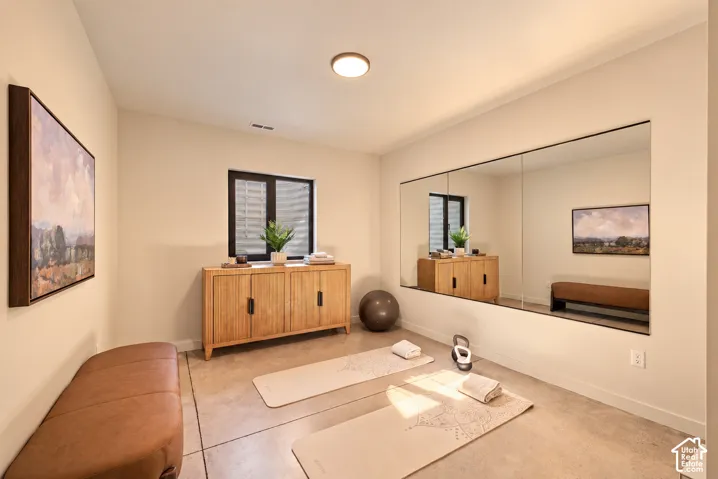 Polished concrete flooring, expansive wall-to-wall mirror, and flush-mount ceiling lighting