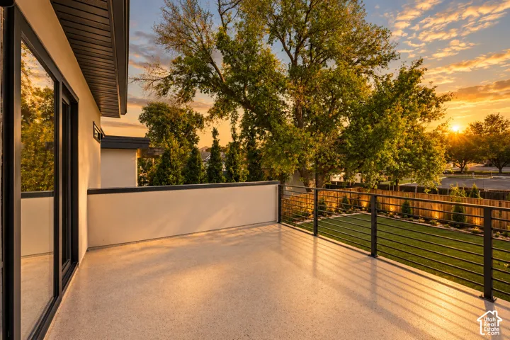 Elevated terrace featuring a solid parapet wall, sleek horizontal metal railing, and durable finish flooring