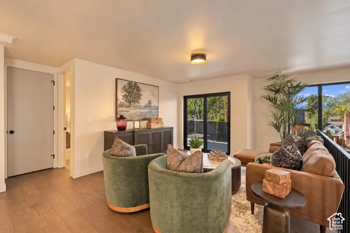 Wood-finish flooring, matte black hardware, flush-mount circular lighting, and sliding glass doors with black framing