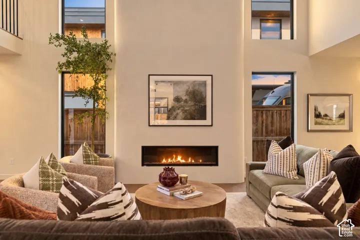 Double-height ceiling, floor-to-ceiling recessed hearth with linear gas fireplace, and vertical windows