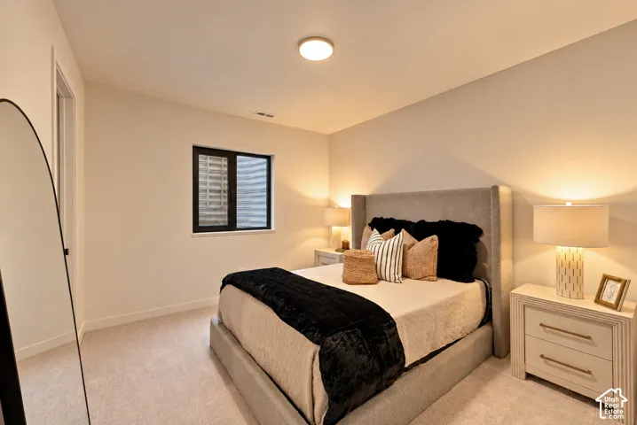 Neutral-toned carpeted flooring, window with dark framing, and flush-mount overhead lighting