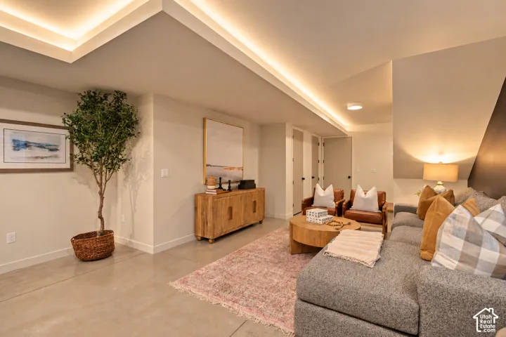 Interior space featuring a recessed tray ceiling with integrated cove lighting and smooth concrete flooring