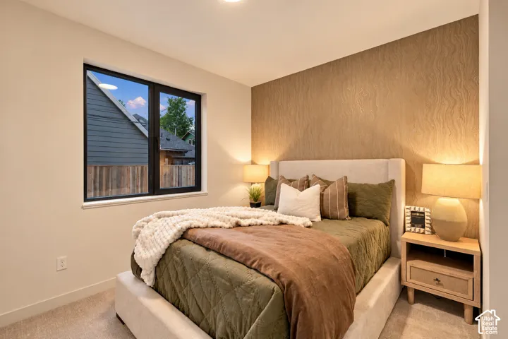 Neutral carpeting, textured accent wall, and large window with black frame