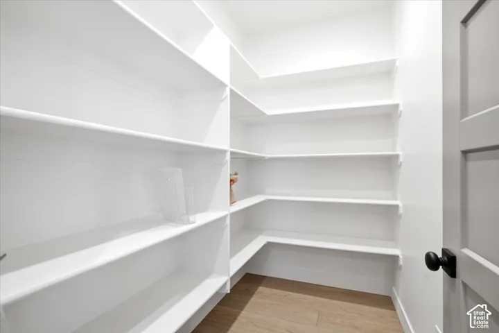 Walk-in pantry featuring white wrap-around shelving