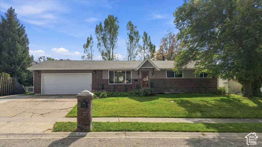 Single-story residence featuring a combination brick and horizontal siding exterior, attached two-car garage, front-facing gable roofline, and established landscaping