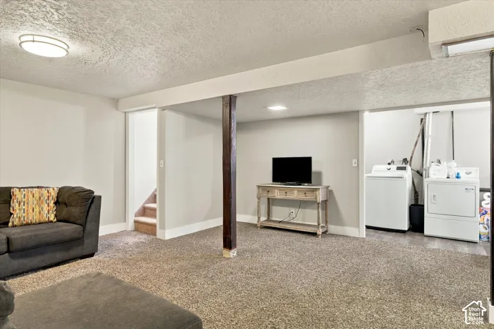 Finished interior space featuring neutral wall paint, carpeting, a ceiling-mounted light fixture, and a support column