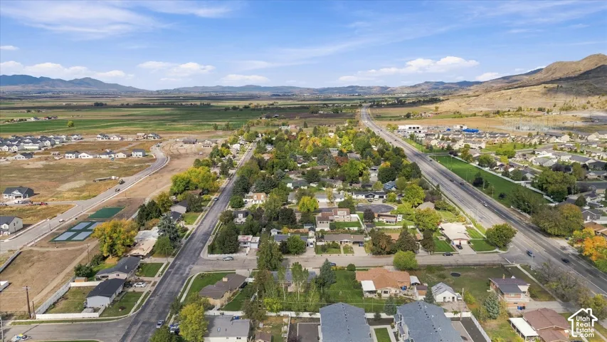 Aerial perspective featuring expansive valley topography, mountain range horizons, and mature canopy trees