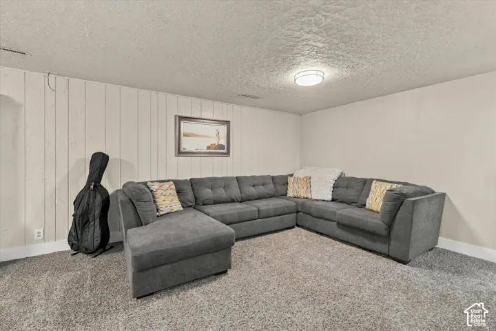 Neutral-toned room featuring textured walls, vertical paneled wall detailing, and a flush-mount circular ceiling light