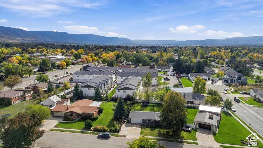Aerial perspective featuring mature trees, manicured lawns, and prominent mountain backdrop