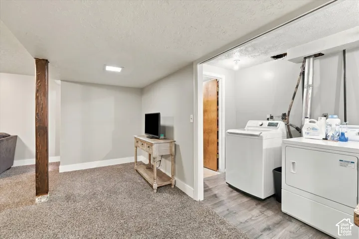 Interior area featuring carpeted flooring, a structural wood-finish support post, and a dedicated laundry area with hard-surface flooring