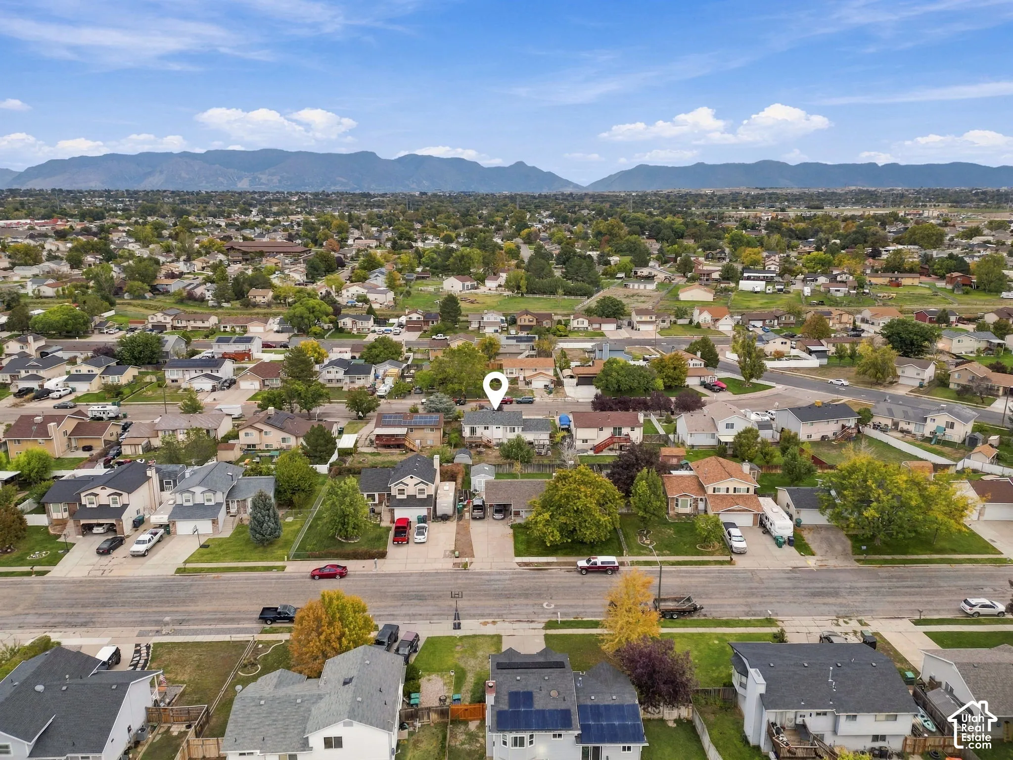 Aerial perspective of residential property featuring a prominent mountain backdrop and established tree canopy