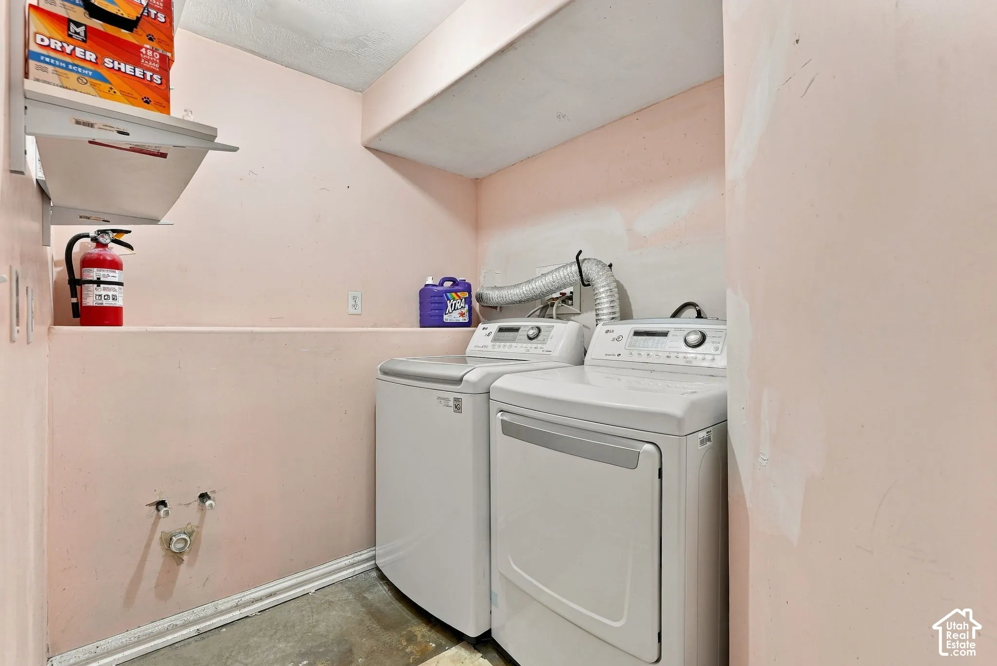 Laundry area featuring a dedicated recessed nook, overhead storage shelving, and plumbing hookups for appliances