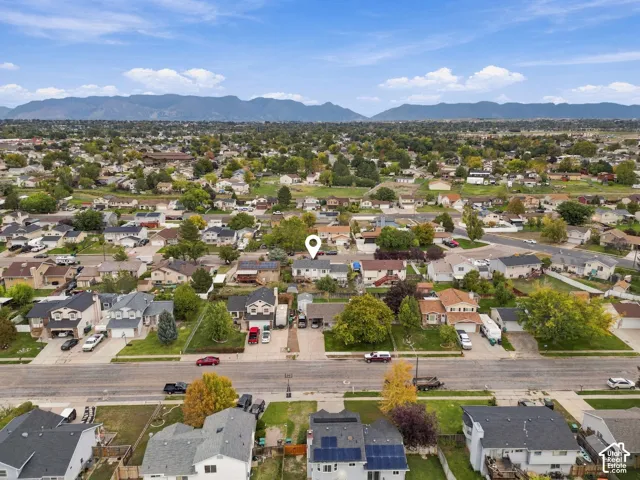 Aerial perspective of residential property featuring a prominent mountain backdrop and established tree canopy