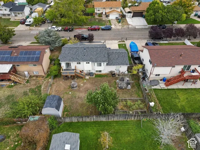 Exterior featuring an elevated wooden deck, a pergola, a detached storage shed, and a fenced backyard
