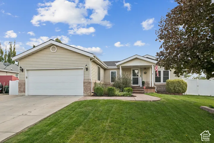 Ranch-style residence featuring horizontal siding, stone veneer accents, an attached two-car garage, a concrete driveway, and a covered front entryway
