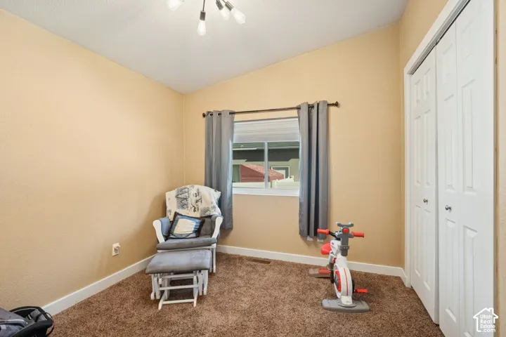 Vaulted ceilings, carpeted flooring, and a closet with bifold doors