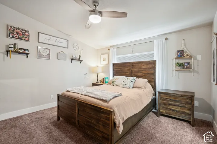 Room featuring wall-to-wall carpeting, a multi-blade ceiling fan with integrated lighting, and a large horizontal window