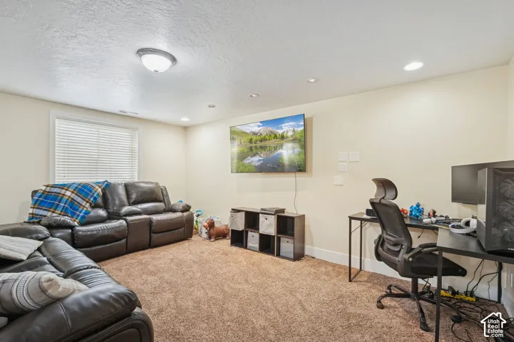 Wall-to-wall carpeting, recessed lighting, and horizontal window blinds